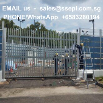 Construction site: workers in helmets install a tall metal security fence; ladders and equipment nearby, with overlaid contact text showing sales@ssepl.com.sg and +65 83280194.